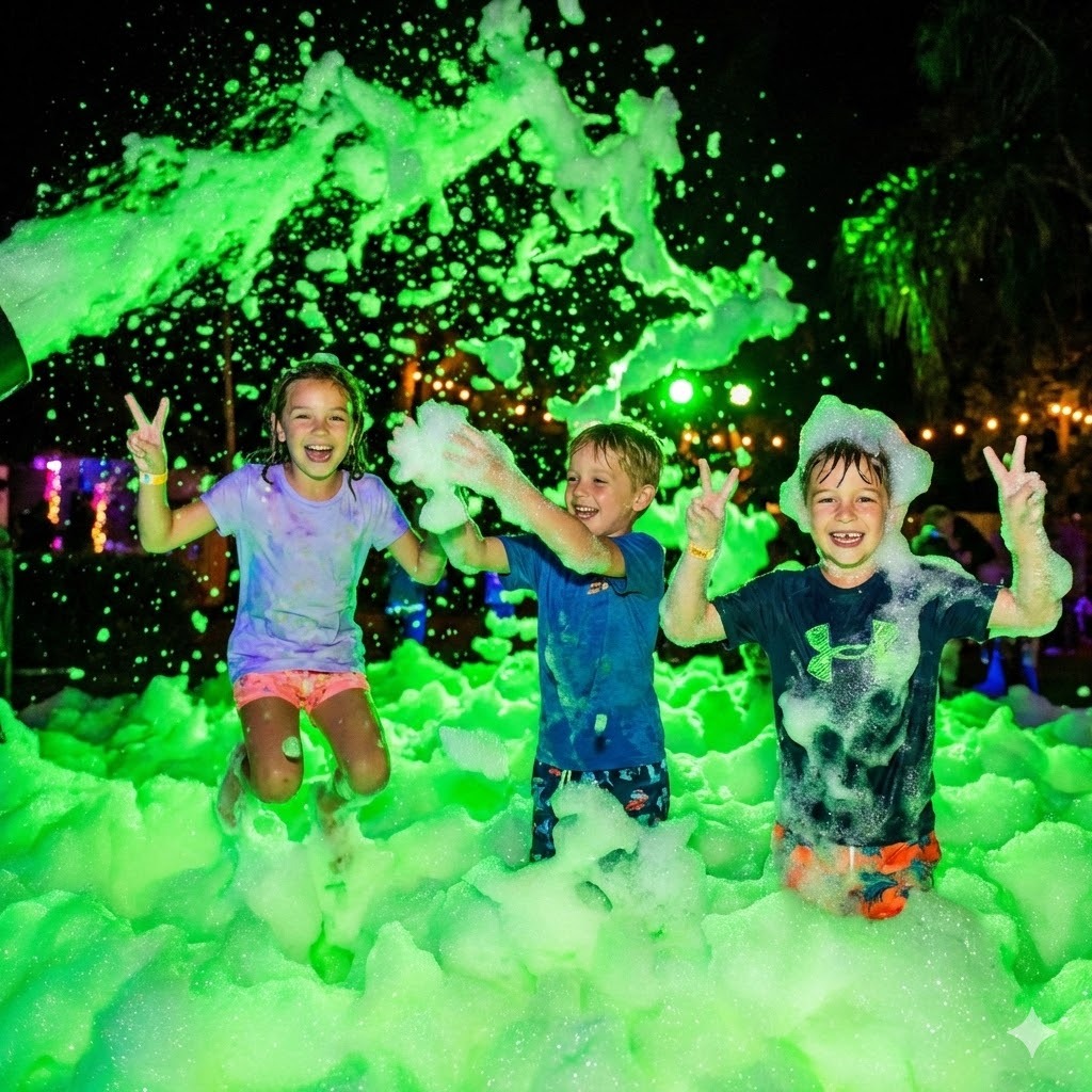 Three kids laughing and jumping in glowing green foam at a nighttime neon foam party rental in Peoria AZ.